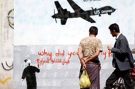 Homens observam crítica aos drones americanos em grafite na rua de Sanaa, capital iemenita