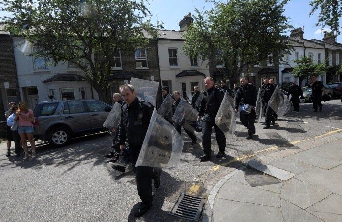 Policiais com equipamentos de segurança se aproximavam de uma das torres do edifício na manhã desta quarta-feira