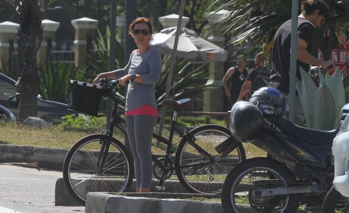 Adriana Esteves e Vladimir Britcha andam de bicicleta na praia da Barra, no Rio