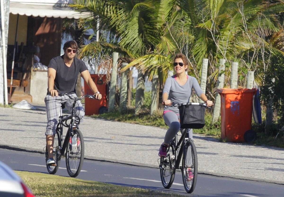 Adriana Esteves e Vladimir Britcha andam de bicicleta na praia da Barra, no Rio