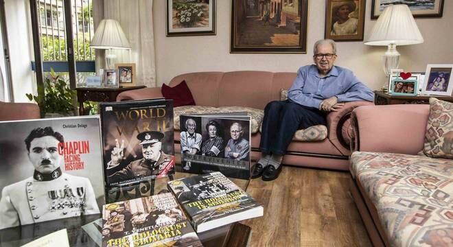 Livros sobre a guerra e quadros com familiares são dispostos na sala