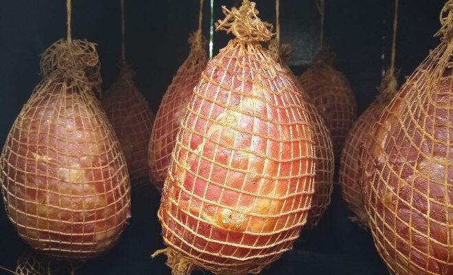 Depois de passar por um processo de cura e ficar horas exposto à fumaça, o corte suíno se transforma num tender natalino
