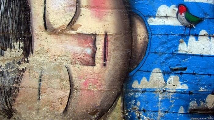 Esse grafite mostra um menino palestino morto na violência da região. O guia explica que ele está sorrindo porque os mártires vão direto para o céu