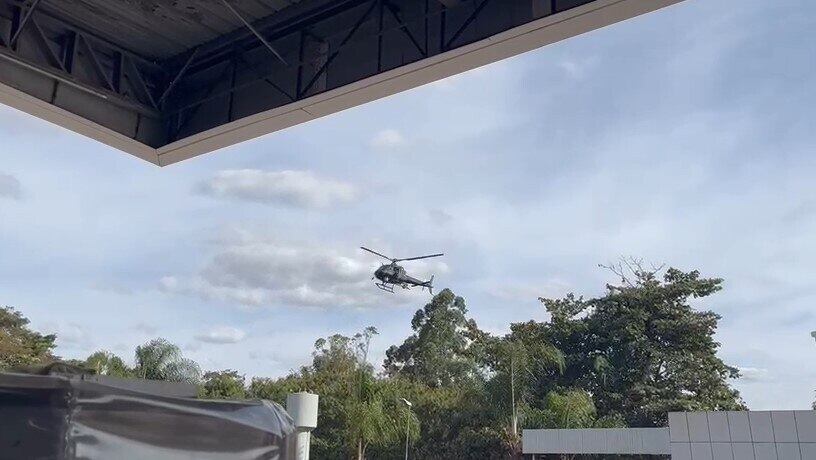 Momento em que helicóptero da polícia chega ao posto de gasolina