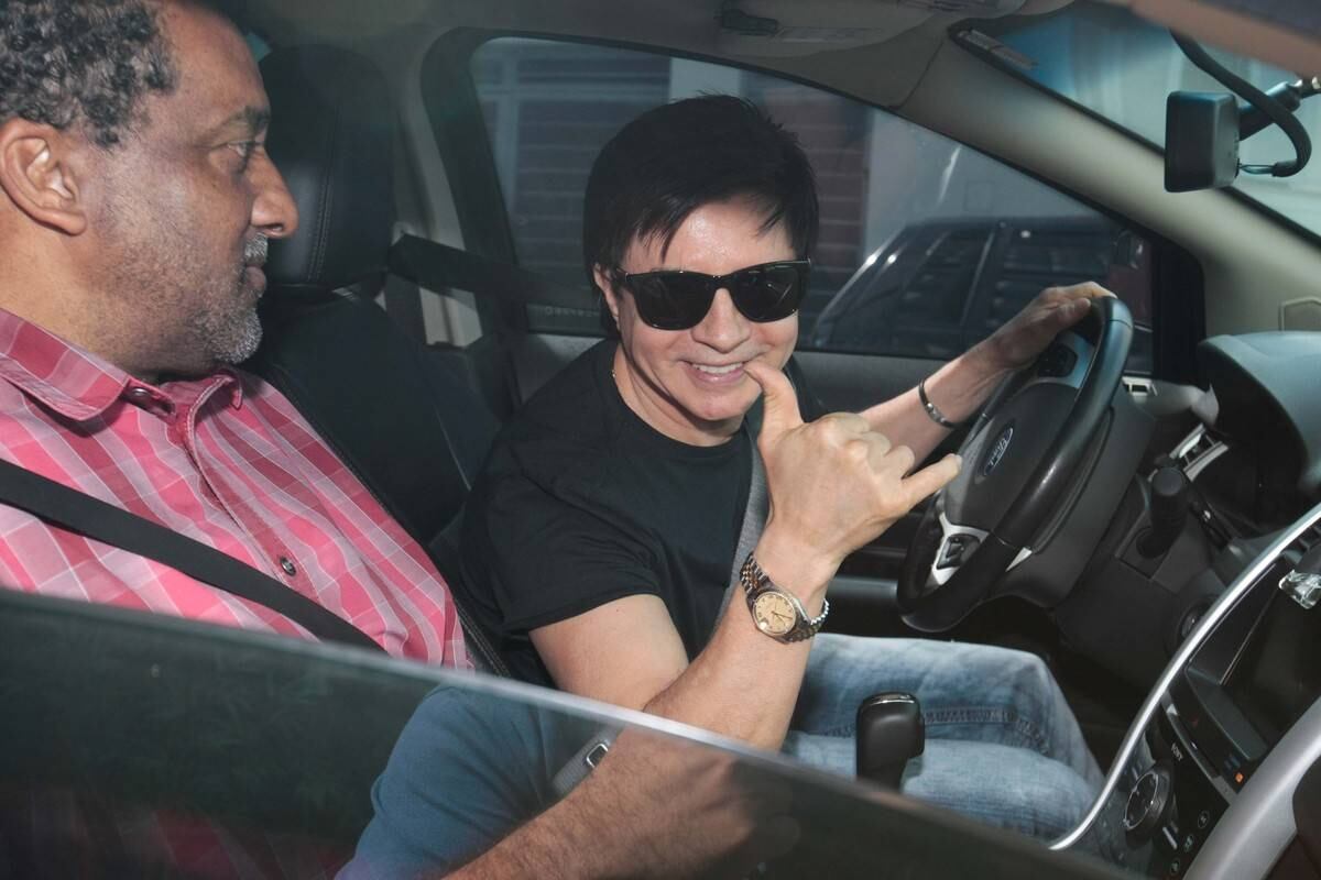 O cantor acenou e sorriu para o fotógrafo

