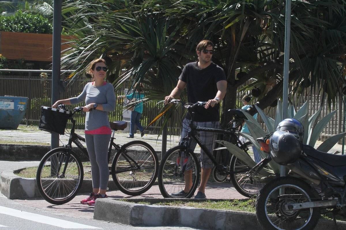 Adriana Esteves e Vladimir Britcha andam de bicicleta na praia da Barra, no Rio
