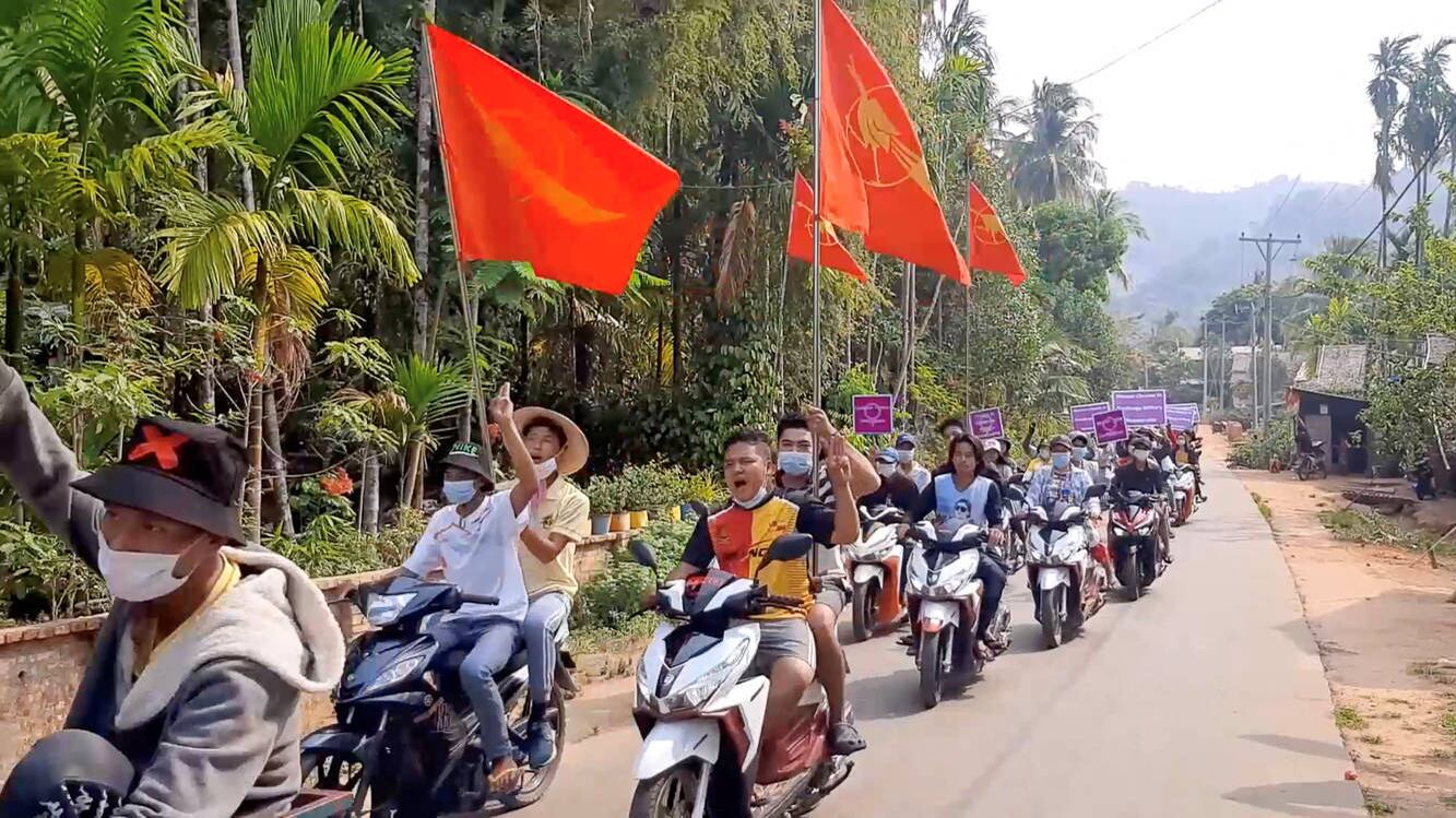 Demonstrators display signs and flags in a motorcycle procession against the ongoing coup, from Nyinmaw to Tizit, Myanmar March 17, 2021 in this still image obtained from social media video. Dawei Watch via REUTERS THIS IMAGE HAS BEEN SUPPLIED BY A THIRD PARTY. MANDATORY CREDIT. NO RESALES. NO ARCHIVES