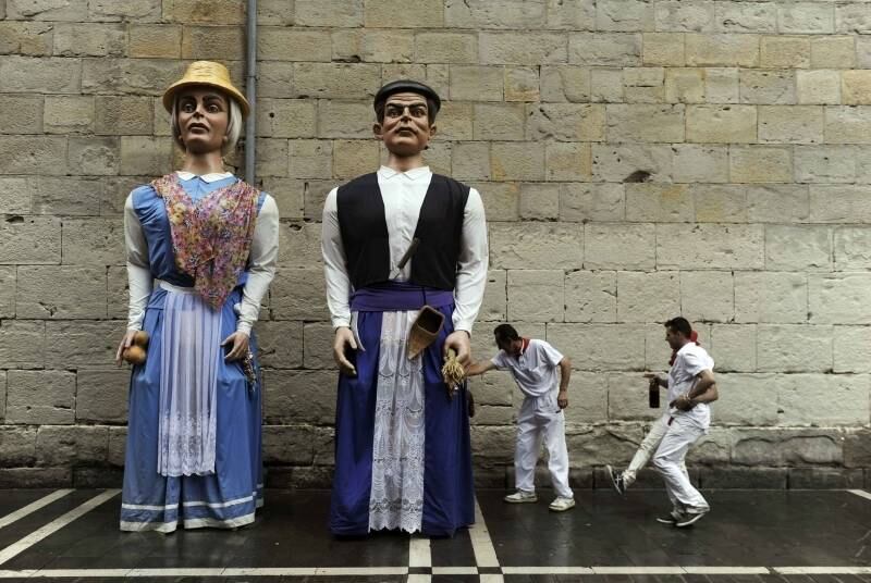 Festeiros se divertem
perto das tradicionais figuras gigantes do Festival de São Firmino, em
Pamplona, na Espanha