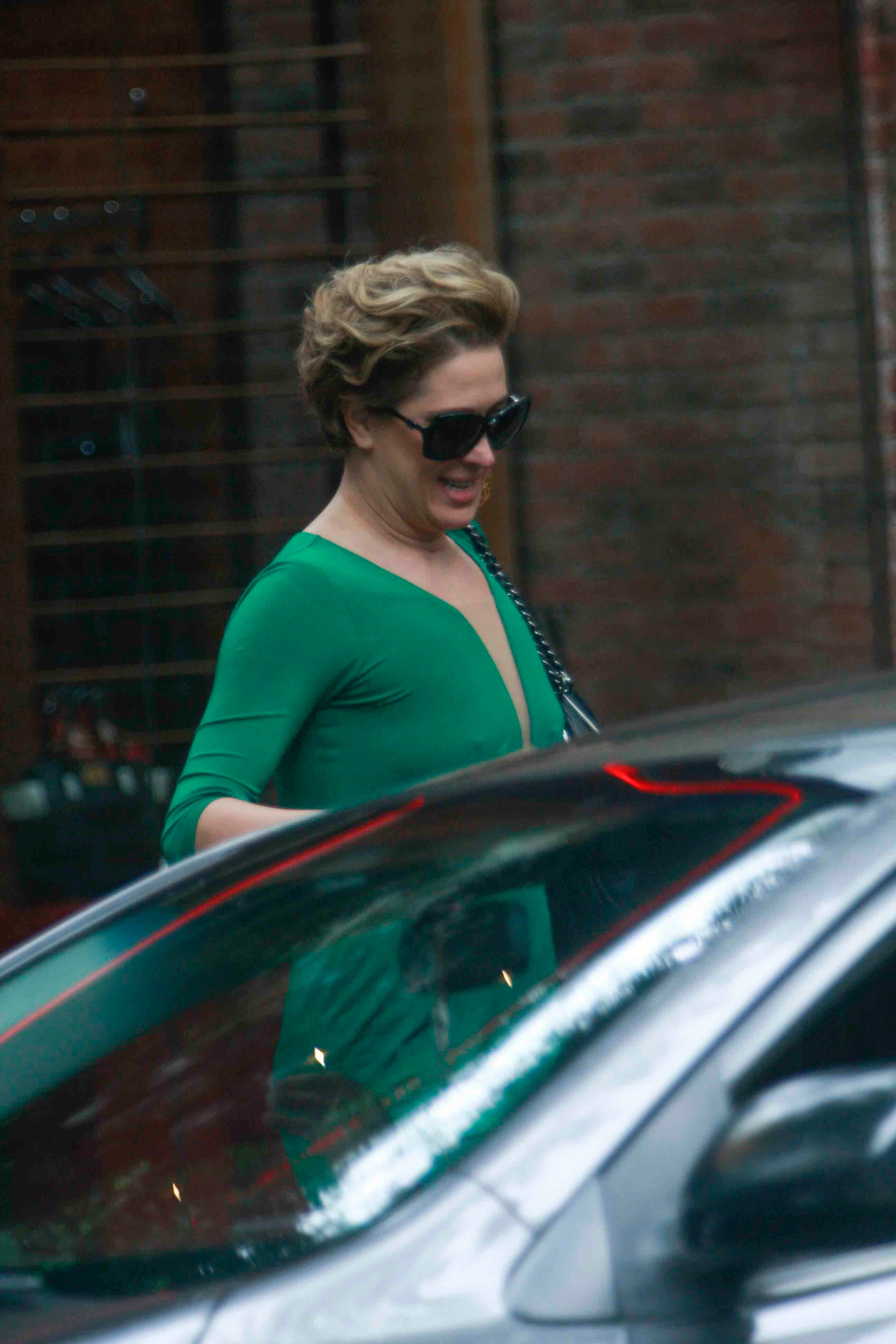 Claudia Raia usava um vestido verde decotado e estava com um penteado impecável
