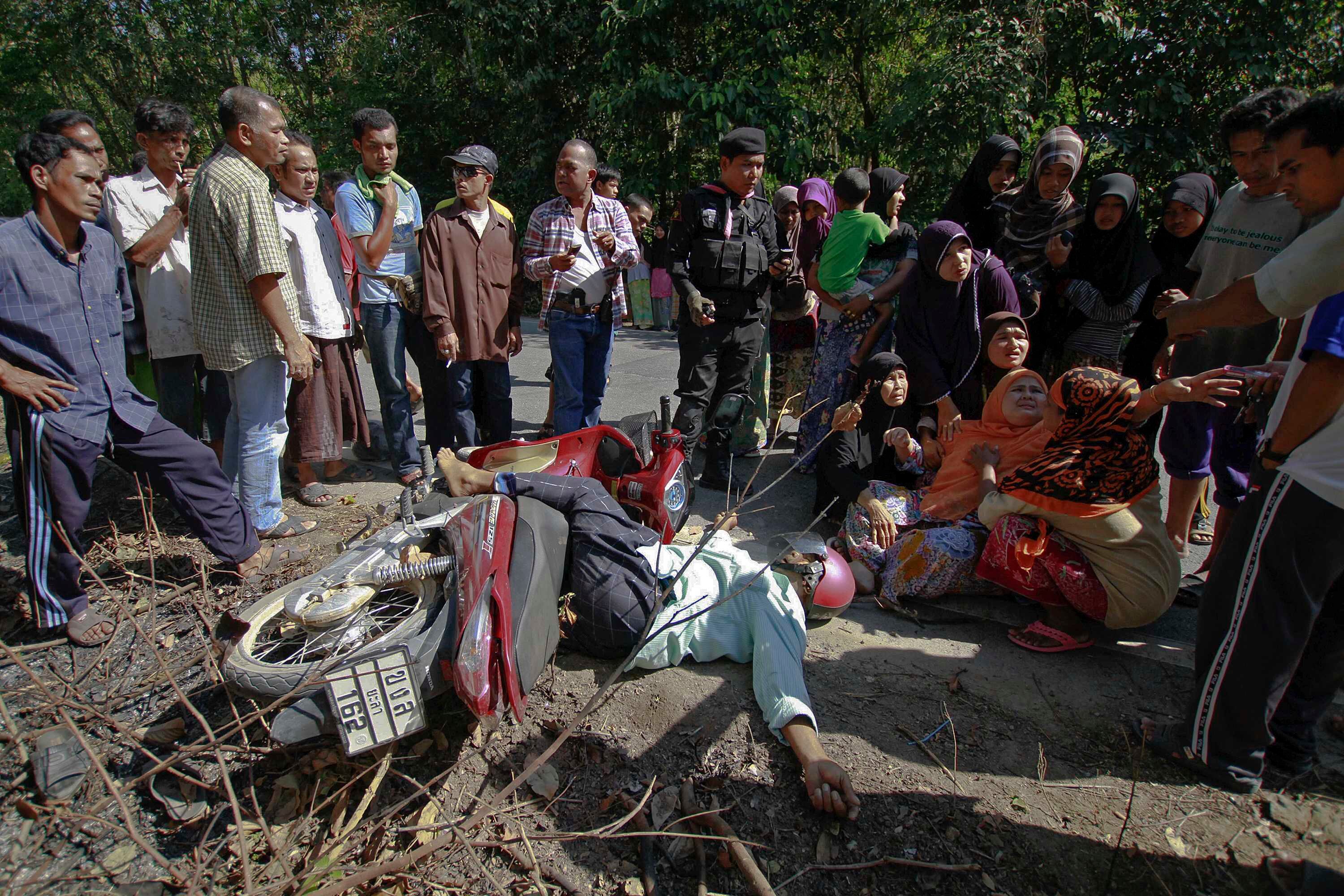 Parentes choram a morte de um chefe de aldeia na província de Pattani, na Tailândia. Segundo a polícia, o homem foi morto a tiros enquanto andava de moto