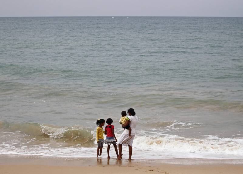 Família de uma vítima do tsunami olha para o mar dez anos após a tragédia