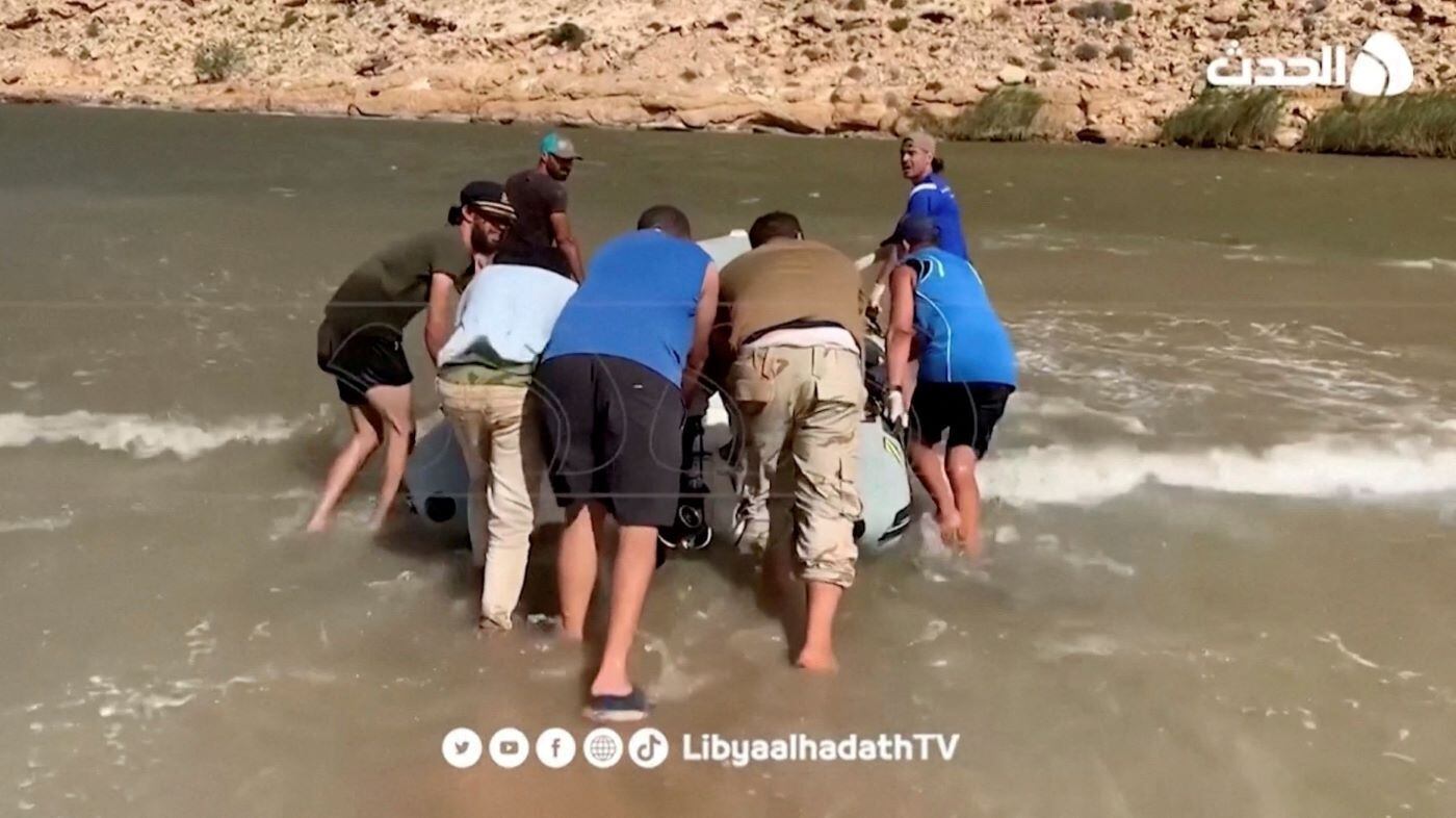 Voluntários empurram um barco a motor para o mar durante uma operação de busca após enchentes mortais, em Derna. A tromba d'água da madrugada de domingo para segunda-feira provocou o rompimento de duas barragens e gerou uma enchente comparável a um maremoto de vários metros, que destruiu prédios, veículos e arrastou milhares de pessoas em sua trajetória