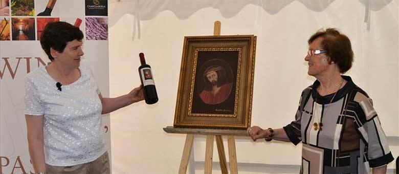 Cecília Gimenez ao lado da obra que será utilizada nos rótulos de uma linha de vinhos