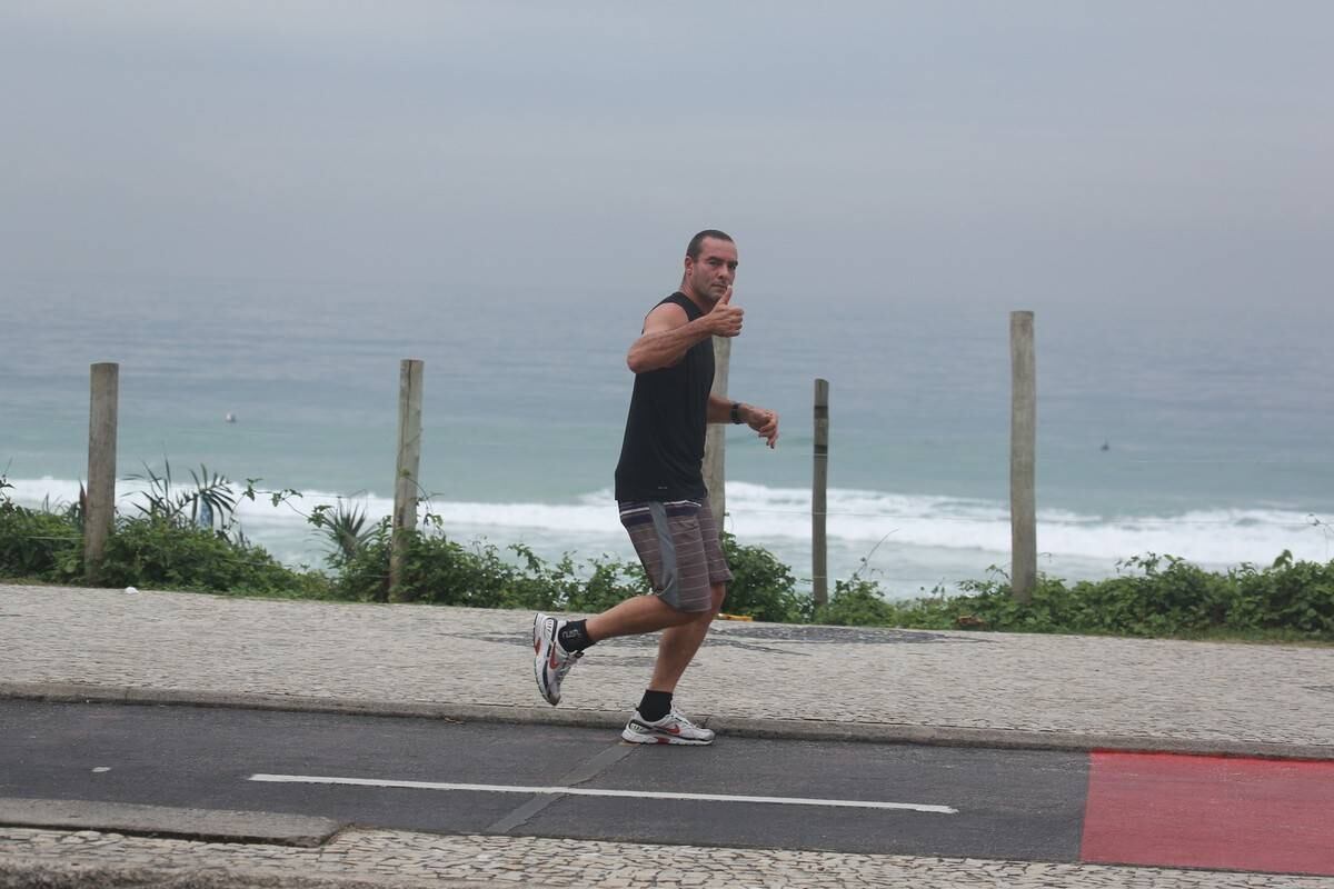 Paulo Zulu é fotografo correndo na praia da Barra da Tijuca, no Rio