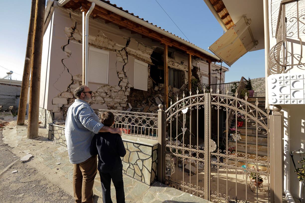 People look at a damaged house following an earthquake in the village of Damasi, in central Greece, March 3, 2021. REUTERS/Thanos Floulis