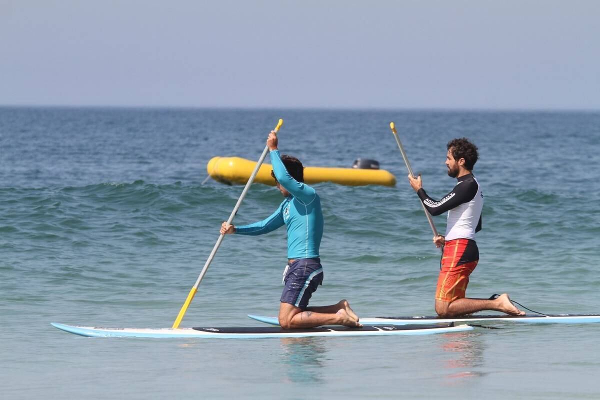 Bruno Gagliasso e Ricardo Pereira praticam stand up paddle na praia da Barra da Tijuca, no Rio