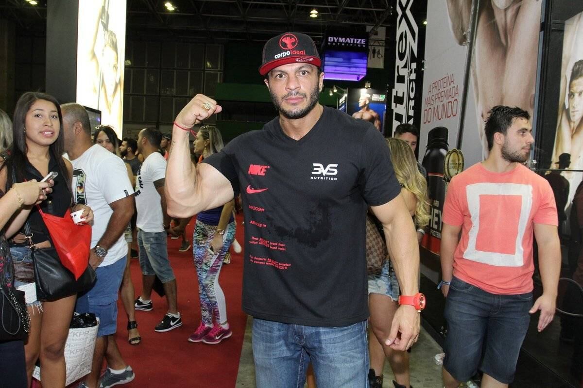Mostrando os músculos no tradicional gesto dos fortões, o vencedor do primeiro Big Brother Brasil participou do segundo dia da feira 