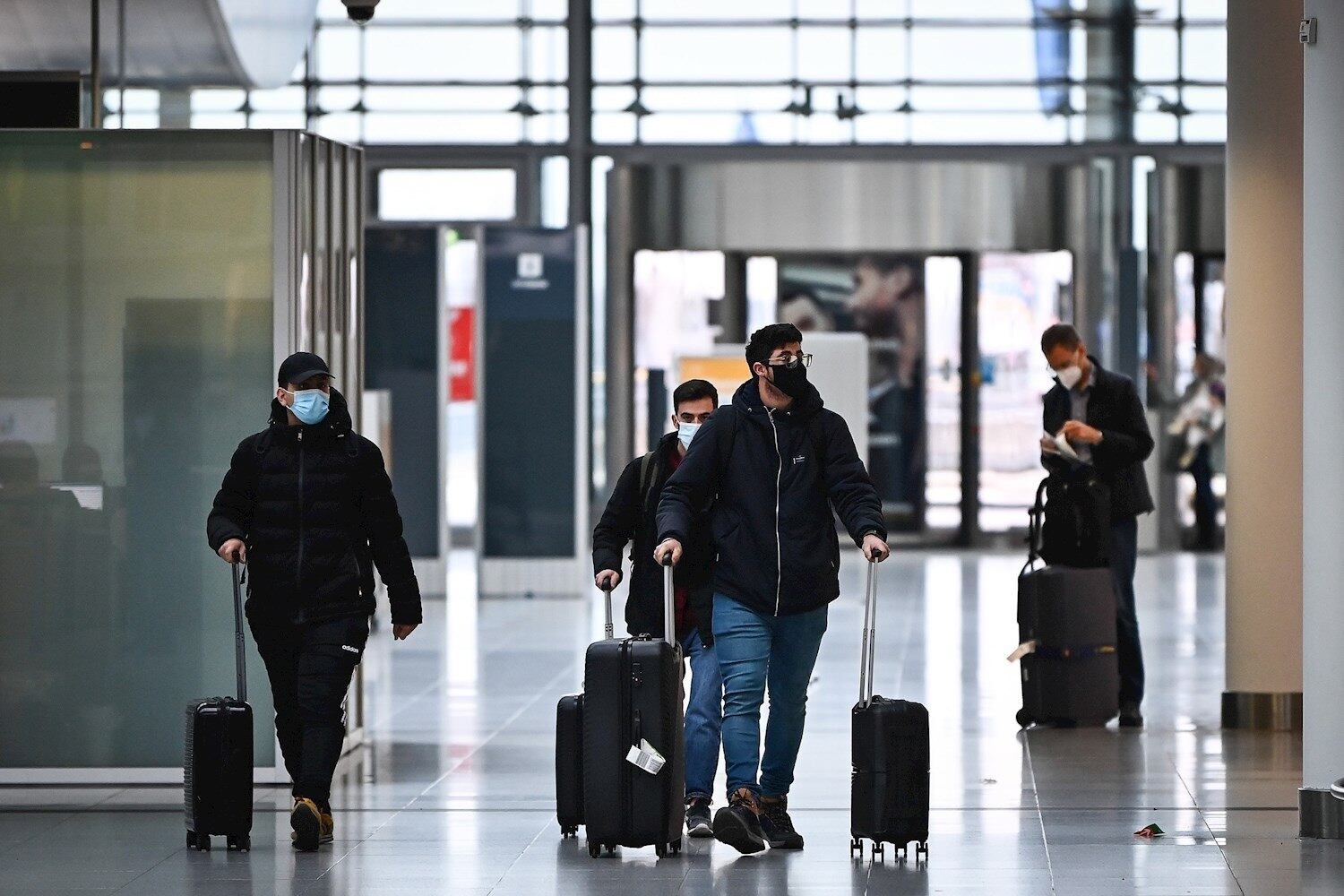 Munich (Germany), 27/11/2021.- Travellers wearing protective face masks arrive at the airport in Munich, Germany, 27 November 2021. The spread of a new potentially more dangerous variant of coronavirus, the B.1.1.529 Coronavirus variant Omicron, in southern Africa has caused international concern. Experts fear that it could be highly contagious because of an unusually large number of mutations and could also penetrate the protective shield of vaccines more easily. Many countries placed travel ban on flights to and from Southern African countries. (Alemania) EFE/EPA/PHILIPP GUELLAND