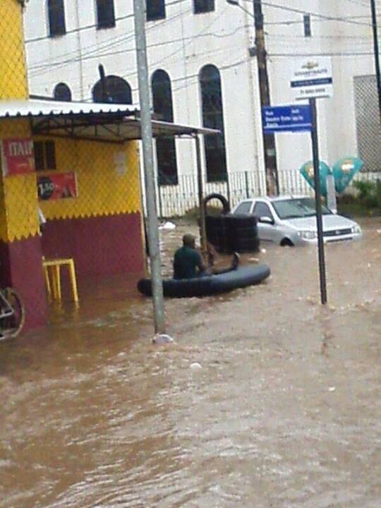 Homem tem ideia criativa e usa colchão inflável para enfrentar a chuva na capital baiana.