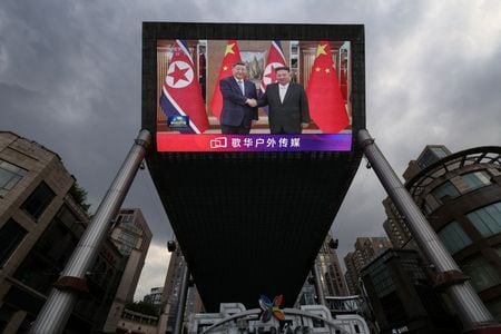 Tela gigante em uma área de compras em Pequim mostra imagens do presidente chinês, Xi Jinping, visitando a Coreia do Norte