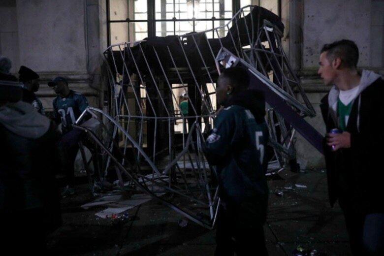Os fãs de Philadelphia Eagles se reúnem para assistir sua equipe no Super Bowl LII contra os Patriotas da Nova Inglaterra
PHILADELPHIA, PA - 5 DE FEVEREIRO: os fãs passam um dossel do hotel destruído no Centro da Cidade depois que as Águias da Filadélfia derrotaram os Patriotas da Nova Inglaterra para ganhar o Super Bowl em 5 de fevereiro de 2018, na Filadélfia, Pensilvânia. (Foto de Aaron P. Bernstein / Getty Images)
