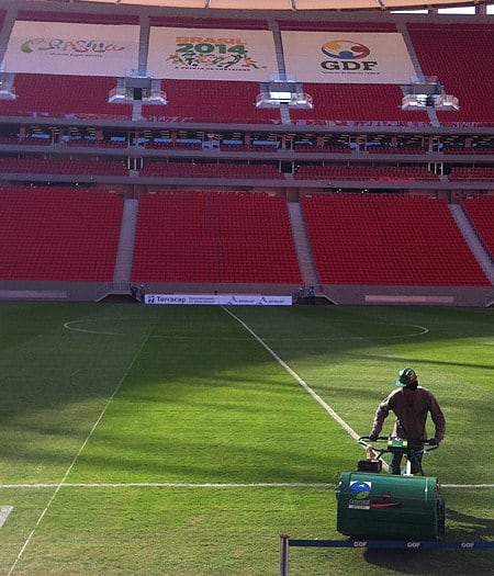 Poucas horas antes do início do jogo, operários ainda dão o retoque final no gramado do Ex-Mané Garrincha