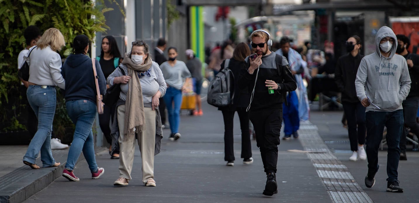 Pedestres se protegem contra o frio em São Paulo