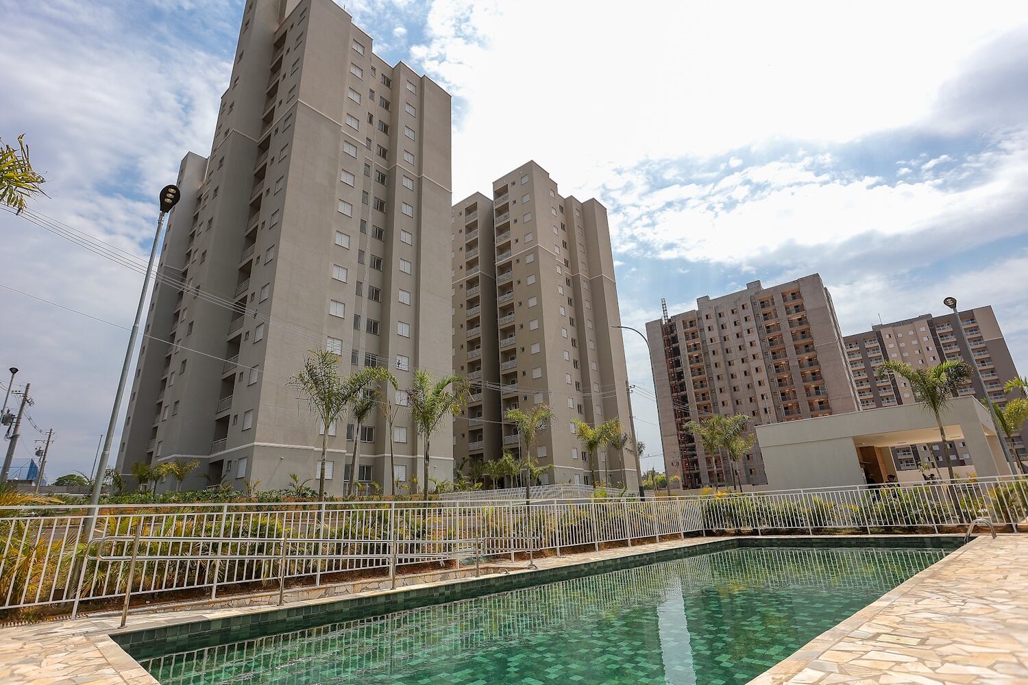 Piscina em primeiro plano, com prédios residenciais ao fundo