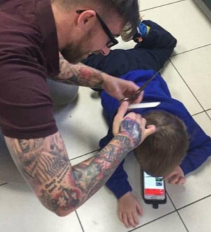 Quando o menino estava deitado no chão, mexendo no celular, sua mãe pediu para que o cabeleireiro aproveitasse a chance
