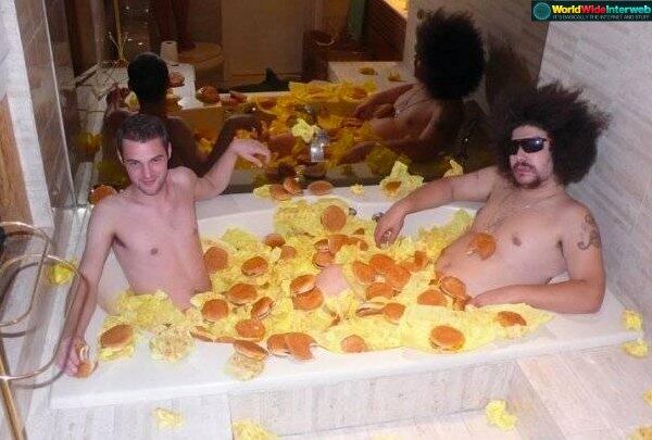 Pra registrar esta imagem de dois caras tomando banho de hambúrguer e tortilha, um cara teve que subir na tampa da privada. Dá pra ver?