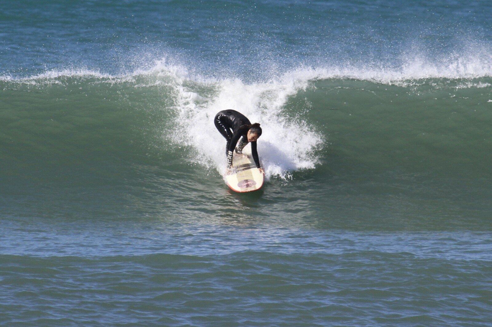 A atriz surfando na praia