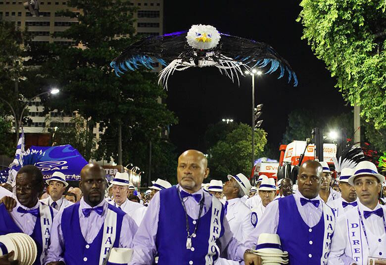 Águia sobrevoa a Sapucaí no desfile da Portela
A Portela ouviu pela primeira vez o grito de "É campeã!" ainda no setor 1, antes de o desfile começar. O público delirou quando um pequeno helicóptero, em forma de águia, sobrevoou a bateria. Ao fim, os gritos voltaram mais fortes