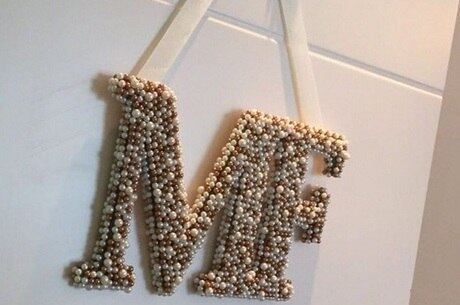 Casal mostra enfeite com as iniciais da filha recém-nascida