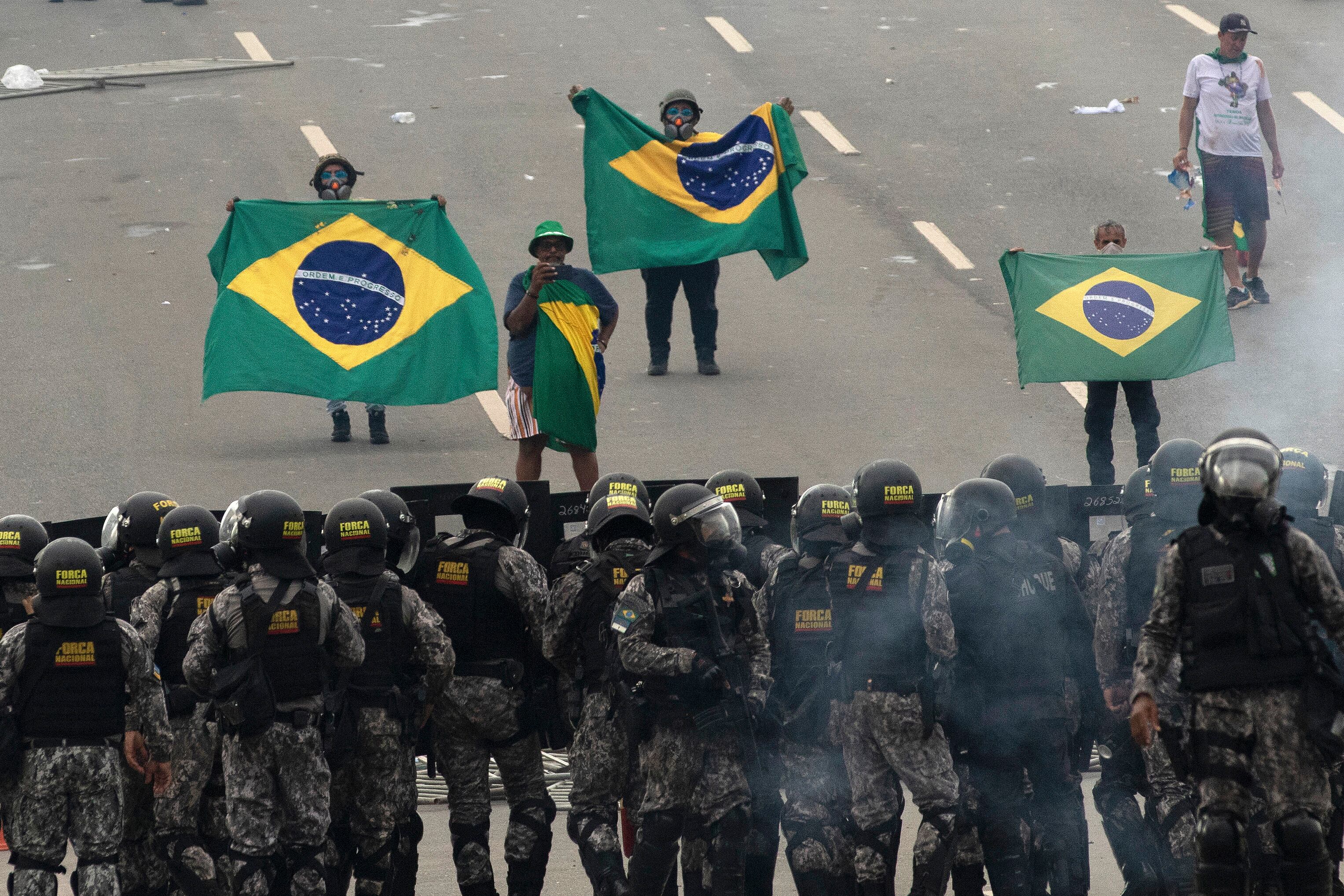 Brasilia 07/02/2023 - Manifestantes invadem predios publicos na praca dos Tres Poderes, na foto manifestantes entram em conflito com policiais da forca nacional entre os predios do Congresso Nacio e Palacio do Planalto