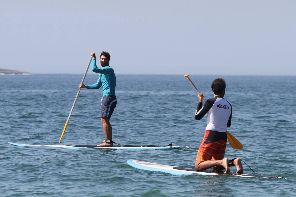 Bruno Gagliasso e Ricardo Pereira praticam stand up paddle na praia da Barra da Tijuca, no Rio
