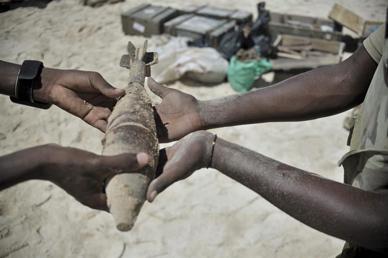 Imagem divulgada pela equipe de apoio informativo da Operação Híbrida da União Africana e ONU mostra um dos soldados da missão da União Africana na Somália repassando material explosivo.

Mais de 200kg de explosivos não detonados foram destruídos nos arredores de Mogadíscio por uma equipe apoiada pela Agência de Ação de Minas Somalis da ONU, responsável por garantir que esses explosivos não causem danos à população civil