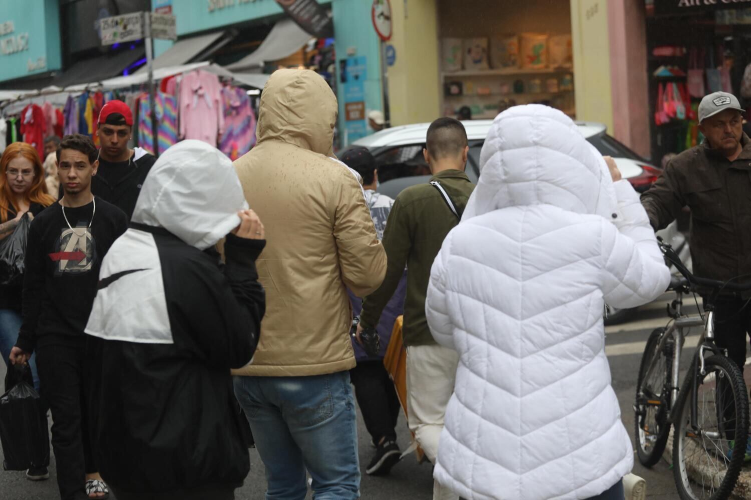 Frio e chuva na tradicional rua 25 de Março, na cidade de São Paulo, neste sábado (26)