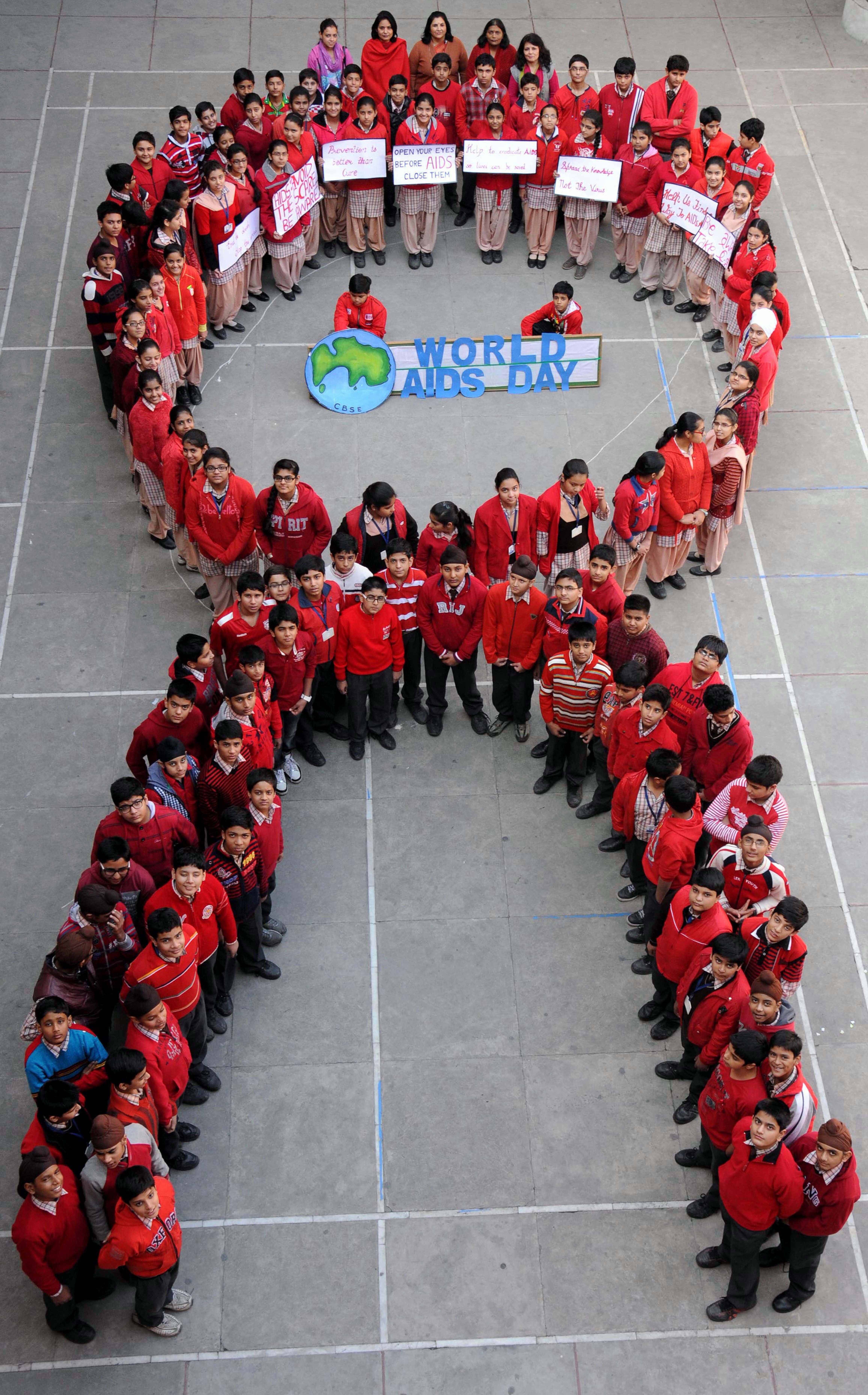 

Estudantes indianos formam a fita
vermelha, símbolo universal da conscientização do combate a Aids

