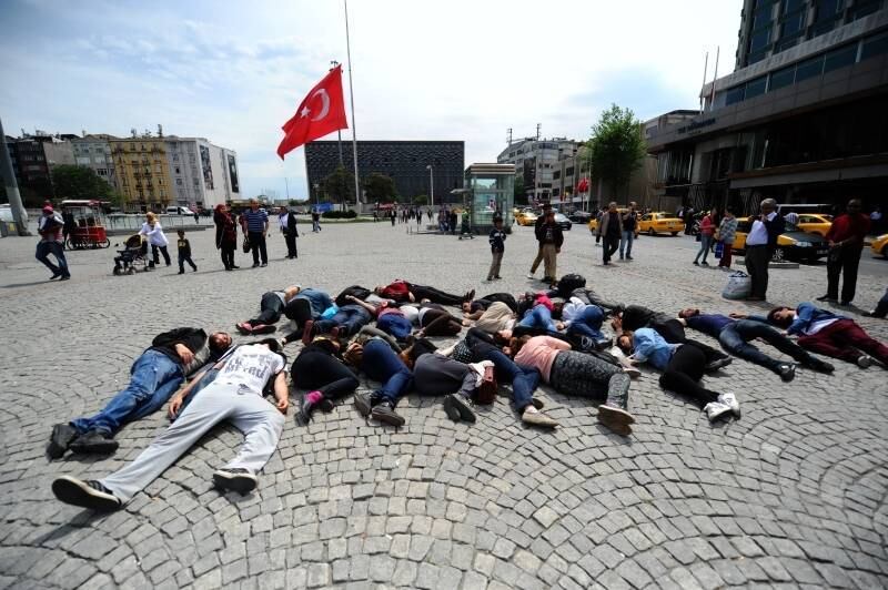 Manifestantes deitam-se
no chão agindo como mineiros mortos em frente à uma bandeira da Turquia na Praça
Taksim, em Istambul. O governo turco declarou 3 dias de luto oficial pelo
desastre na mina de carvão turca, no qual pelo menos 238 pessoas morreram e
centenas continuam presas embaixo da terra