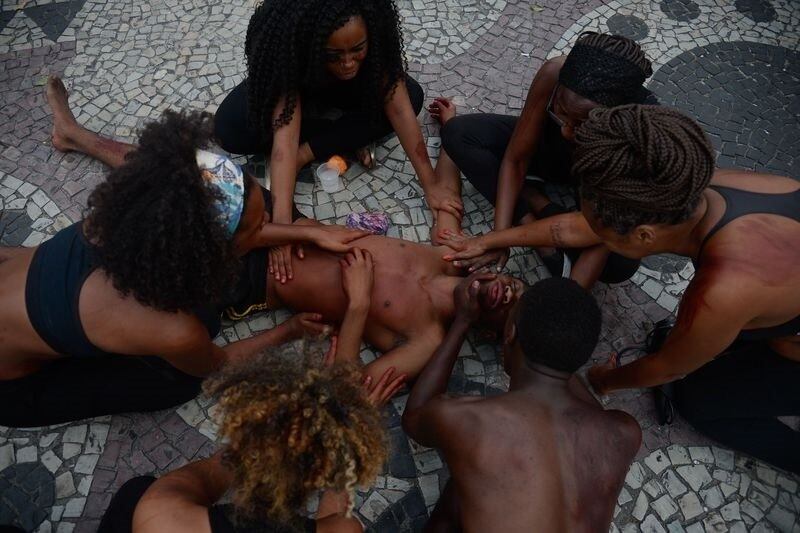 Ativistas da Anistia Internacional encenam mortes de jovens negros em protesto de mães e familiares contra a violência policial