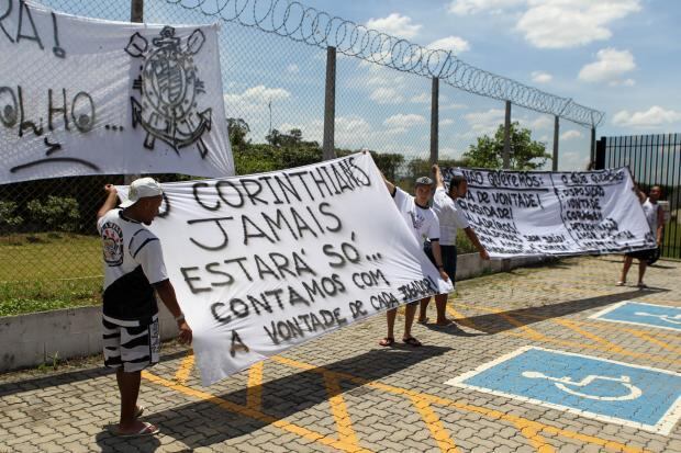 O clima continua tenso no Parque São Jorge. A vitória por 1 a 0 sobre o Criciúma, na noite de sábado (19), em Itu,
distanciou o Corinthians da zona de rebaixamento do Campeonato
Brasileiro, mas parece ainda não ter convencido uma parcela da torcida.
Cinco torcedores identificados com roupas da Camisa 12 foram ao CT do Parque Ecológico no início da tarde desta segunda-feira (21). Eles estenderam faixas no estacionamento destinado à imprensa e cobraram empenho na partida contra o Grêmio, pelas quartas de final da Copa do Brasil, na quarta-feira (23)