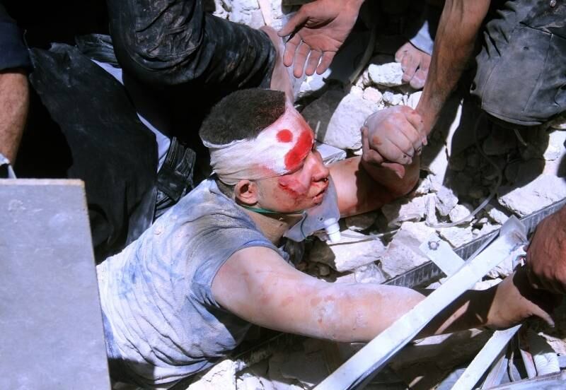 Em Aleppo,
na Síria, homem é socorrido debaixo de destroços após supostos helicópteros do
governo terem bombardeado o norte da cidade, matando pelo menos 20 pessoas