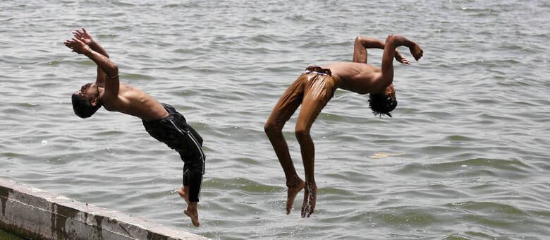 Garotos se refrescam nas águas do rio Sabarmati, na Índia, onde os termômetros chegaram a atingir 47,5º
