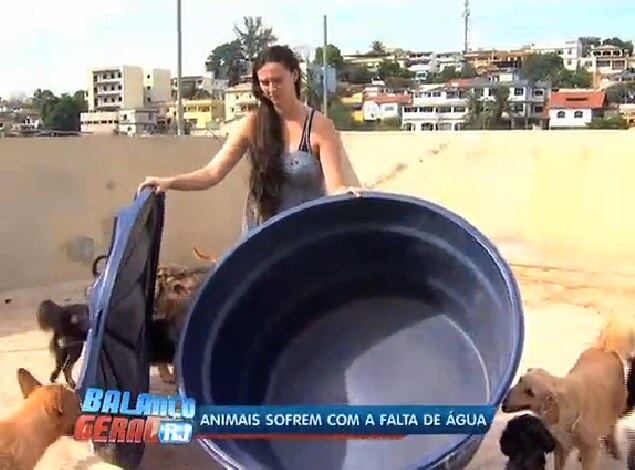 Mulher mostra caixa d'água vazia