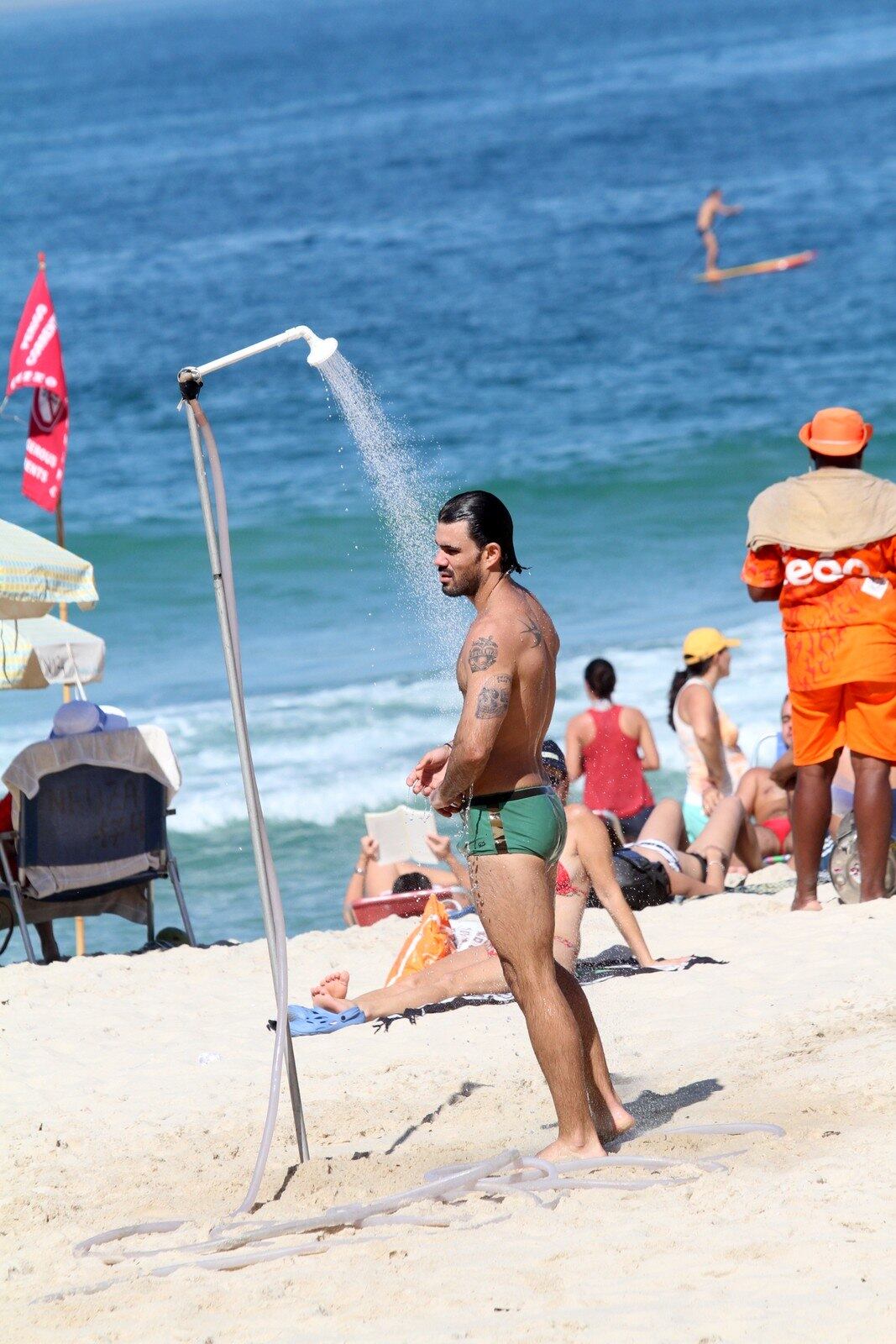Ao sair do mar, Juliano Cazarré tomou uma ducha e exibiu seu físico perfeito