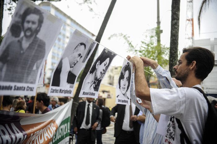 Fotos de vítimas da ditadura foram colocadas por manifestantes em um varal em frente ao quartel. Leia mais
