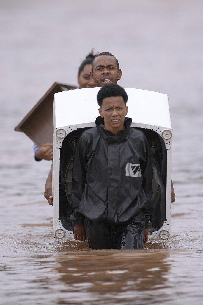 People wade through the water as they remove belongings from their homes in the flooded Brazilian municipality of Juatuba, located in the state of Minas Gerais, on January 10, 2022, after extremely heavy rain has fallen in recent days in the southeastern part of the country.
Douglas MAGNO / AFP