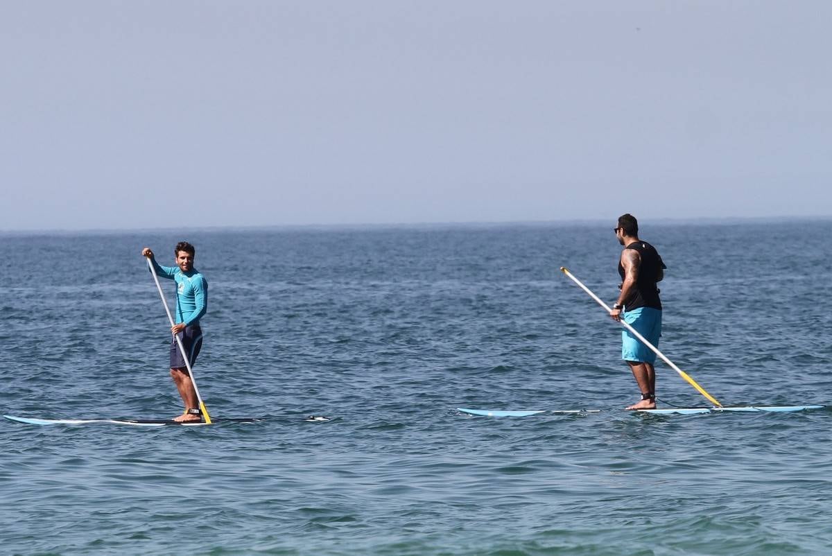 Bruno Gagliasso e Ricardo Pereira praticam stand up paddle na praia da Barra da Tijuca, no Rio