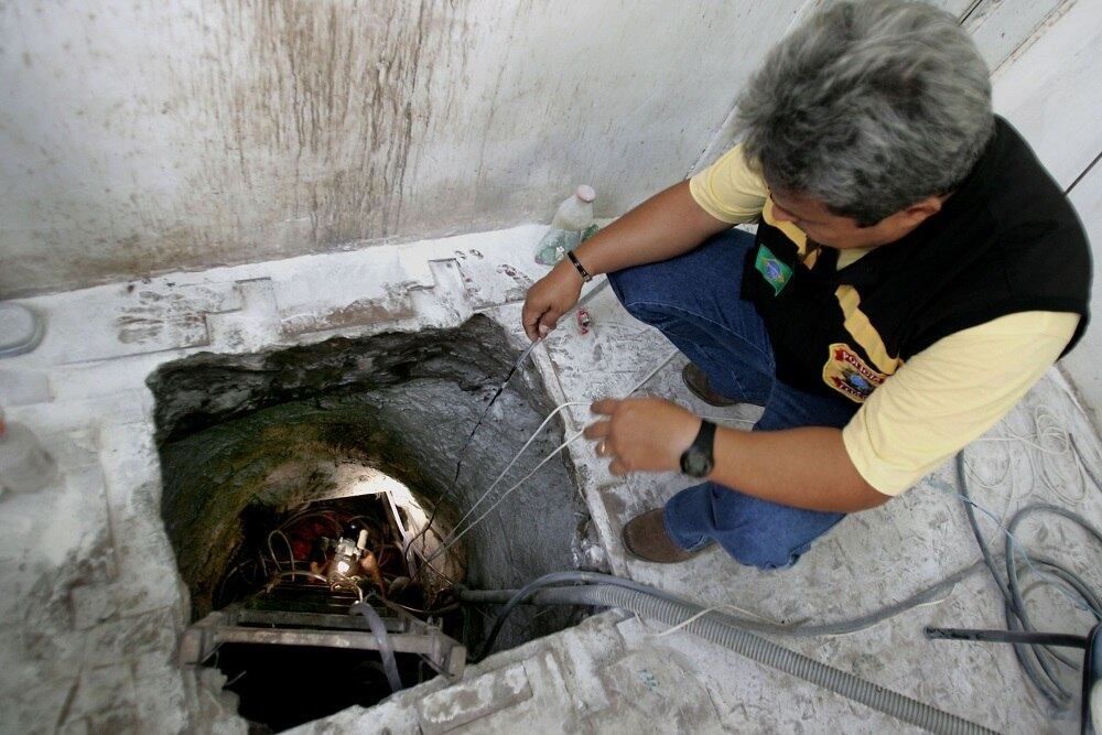 Policial federal observa o interior do túnel utilizado pela quadrilha que arrombou o cofre da agência do Banco Central, em Fortaleza, Ceará. Os criminosos alugaram uma casa próxima, cavaram um túnel de cerca de 80 metros de extensão até o piso da casa-forte e levaram cerca de R$ 150 milhões. Foi o maior roubo da história do BC e um dos maiores a bancos brasileiros, de acordo com a Polícia Federal.