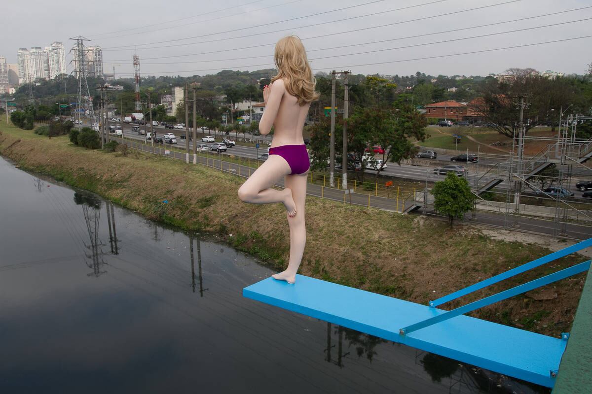 O artista instalou trampolins azuis por pontes da capital paulistas com bonecos prontos para um banho de Rio